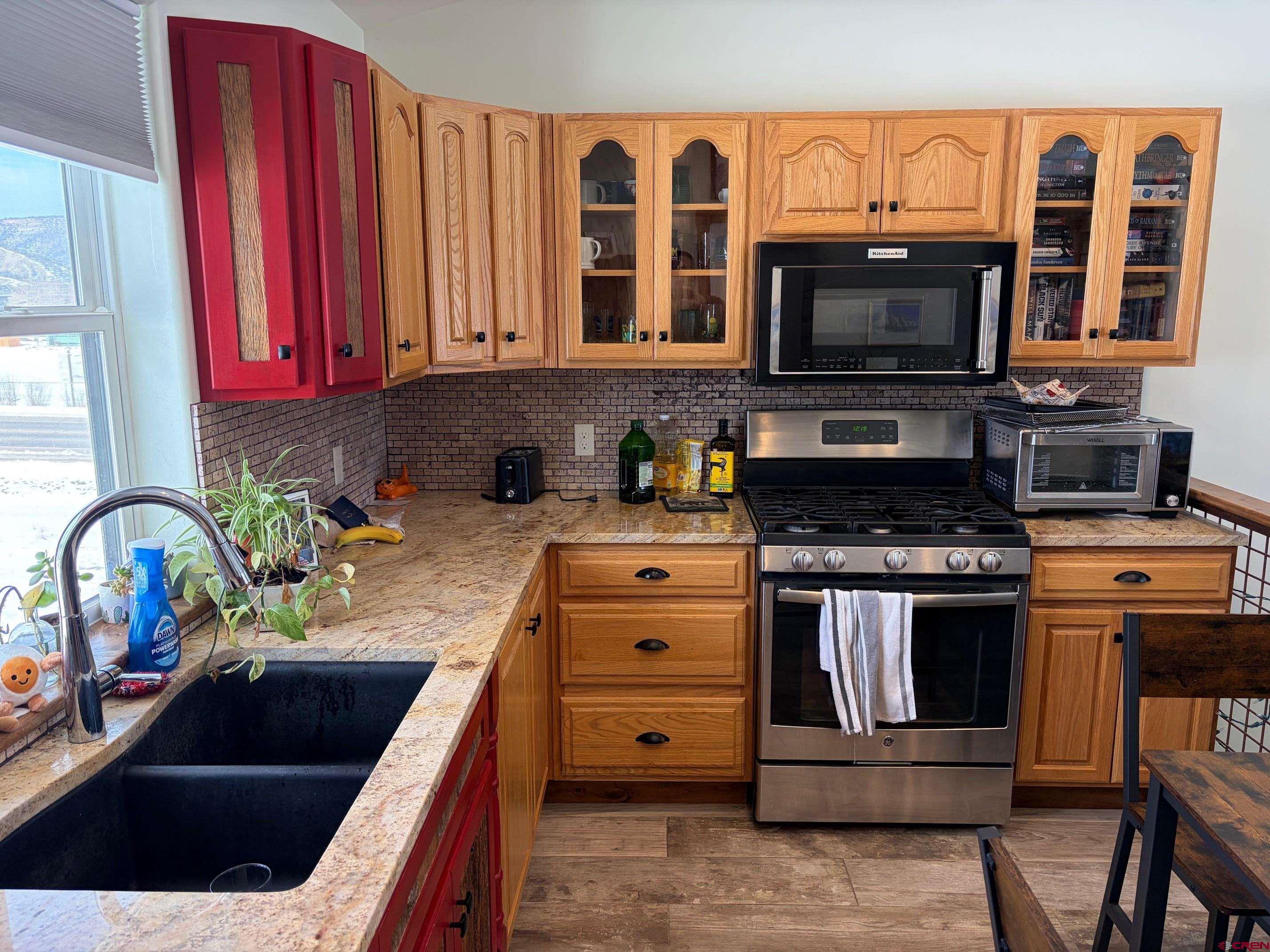 139 South Charlotte Street Ridgway, CO 81432 - Photo 7 of 26 a kitchen with stainless steel appliances granite countertop a stove a sink and a microwave