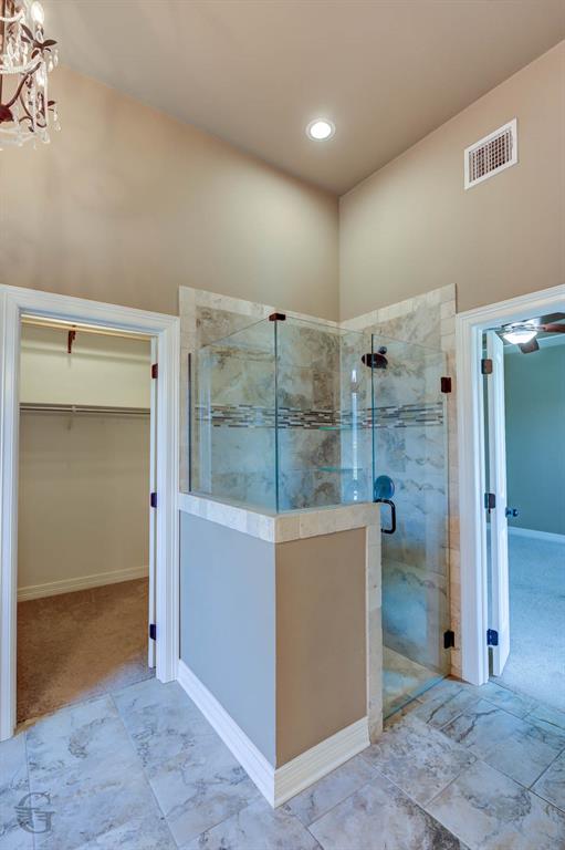 922 Antler Drive Haughton, LA 71037 - Photo 13 of 24 Recessed lighting, tile flooring, glass-enclosed shower, tile shower surround with decorative accent, and a built-in closet with shelving