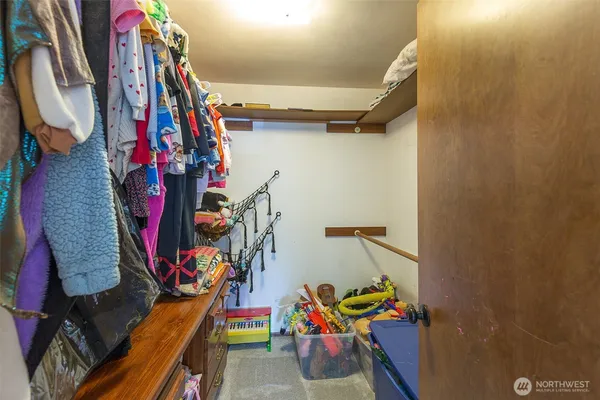 a view of walk in closet with clothes