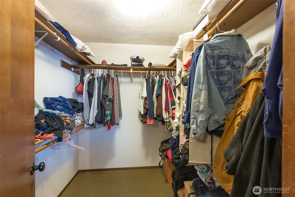 a view of walk in closet with clothes and shoes