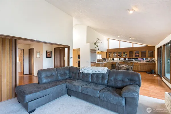 a living room with couches and kitchen view