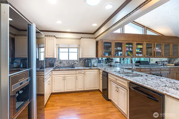 a large kitchen with stainless steel appliances granite countertop a stove and a sink