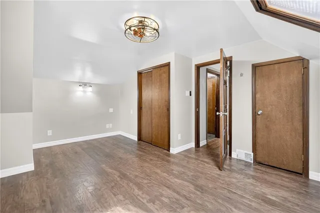 an empty room with wooden floor and window