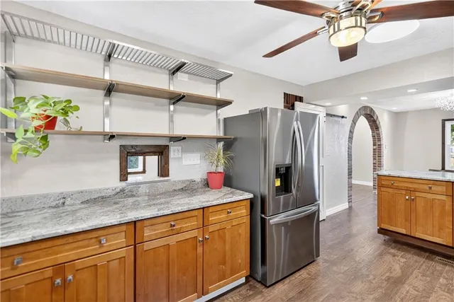 a kitchen with stainless steel appliances granite countertop a refrigerator a oven and a sink
