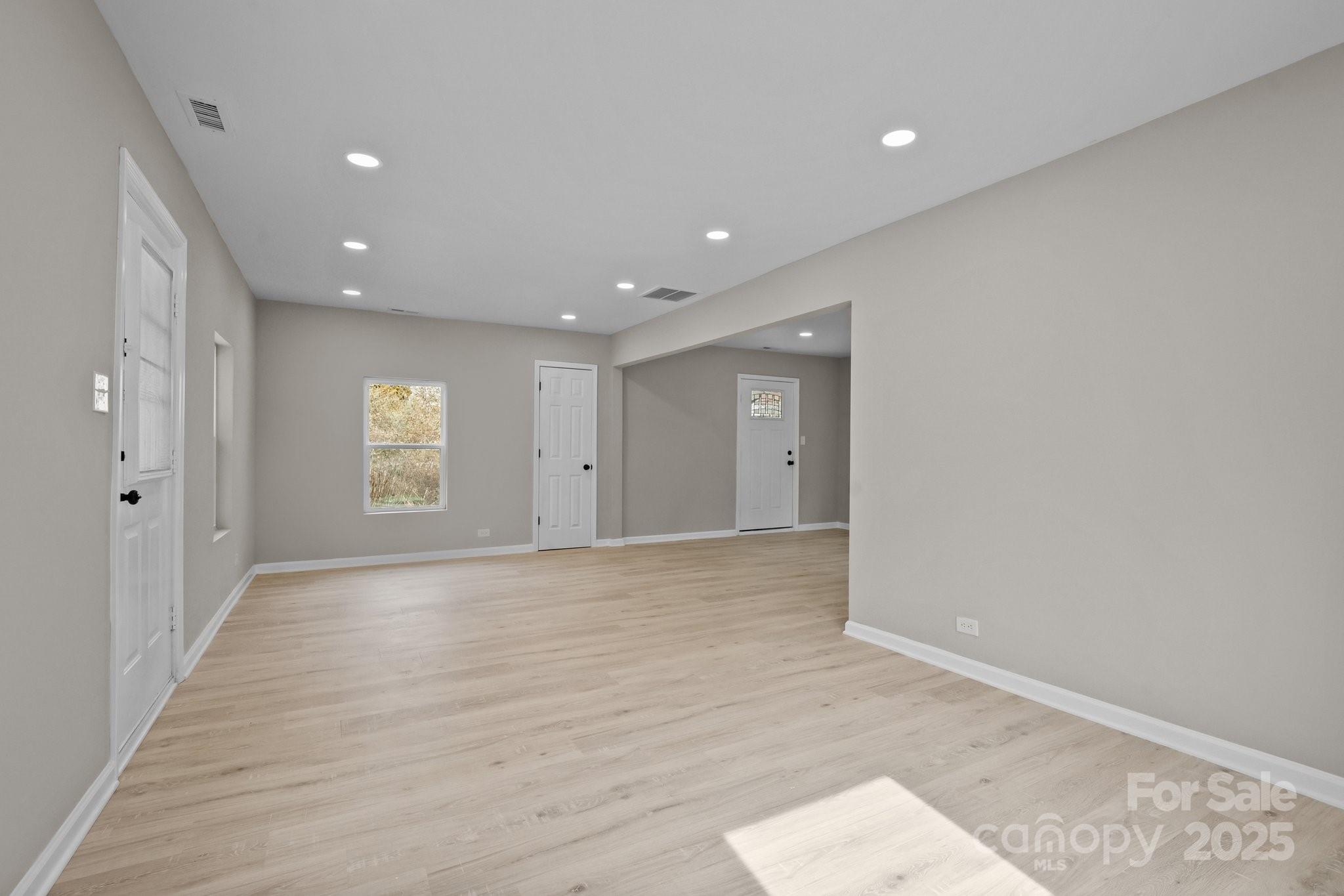 937 Gladstone Road Mocksville, NC 27028 - Photo 11 of 34 an empty room with wooden floor and windows