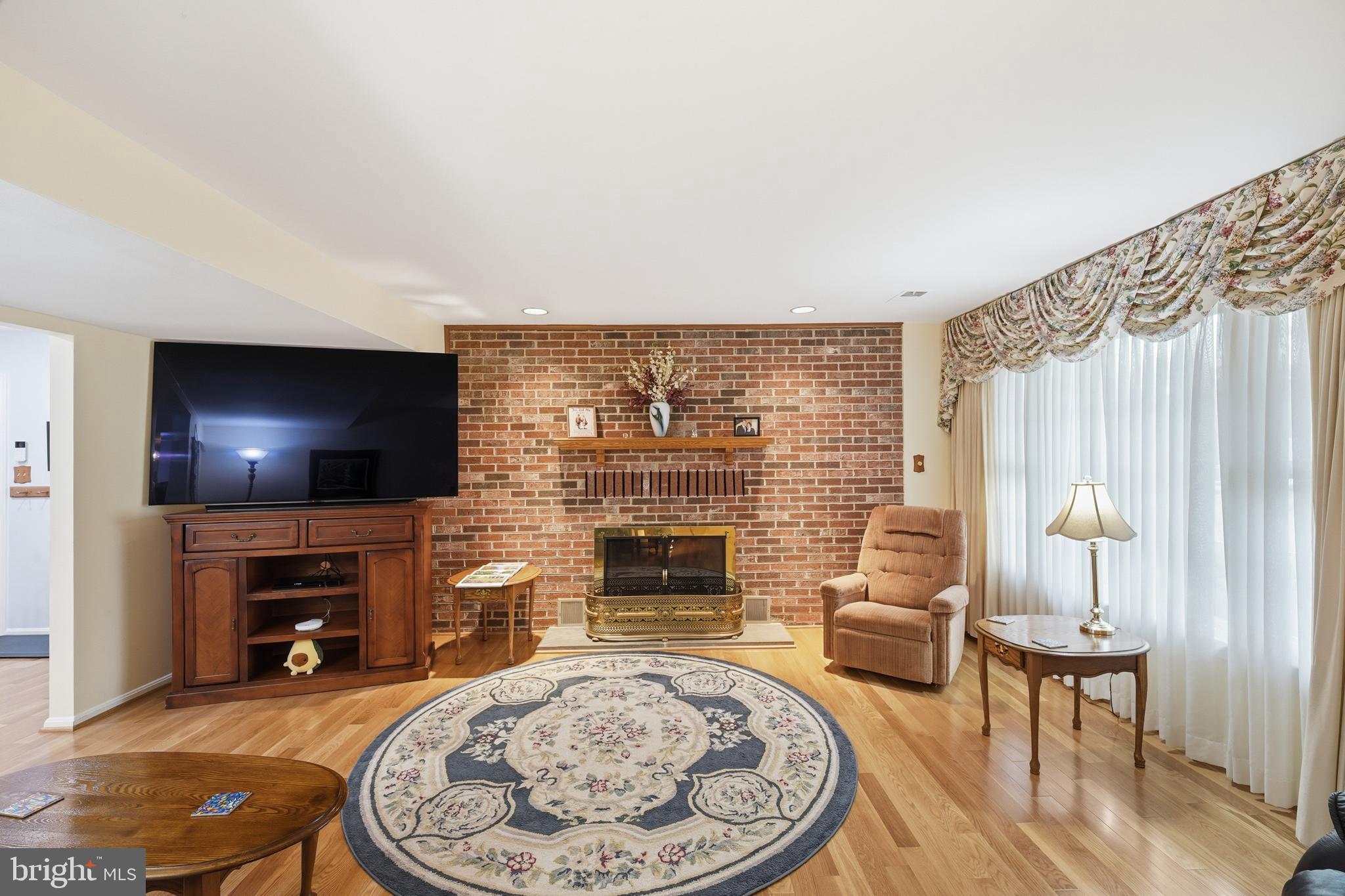 2304 Hidden Valley Lane Silver Spring, MD 20904 - Photo 20 of 54 a living room with furniture a flat screen tv and a fireplace