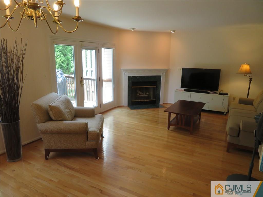 125 Castleton Road Princeton, NJ 08540 - Photo 6 of 24 a living room with furniture a fireplace and a flat screen tv