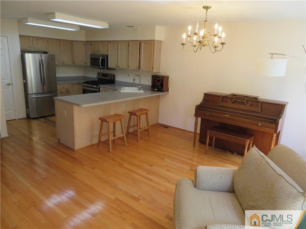 125 Castleton Road Princeton, NJ 08540 - Photo 7 of 24 a kitchen with stainless steel appliances kitchen island granite countertop a refrigerator a stove a microwave oven a sink with a dining table and chairs