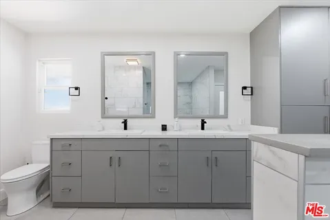 a spacious bathroom with a granite countertop sink mirror and toilet