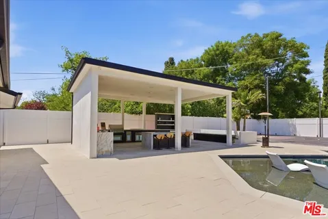 a view of a house with backyard and sitting area