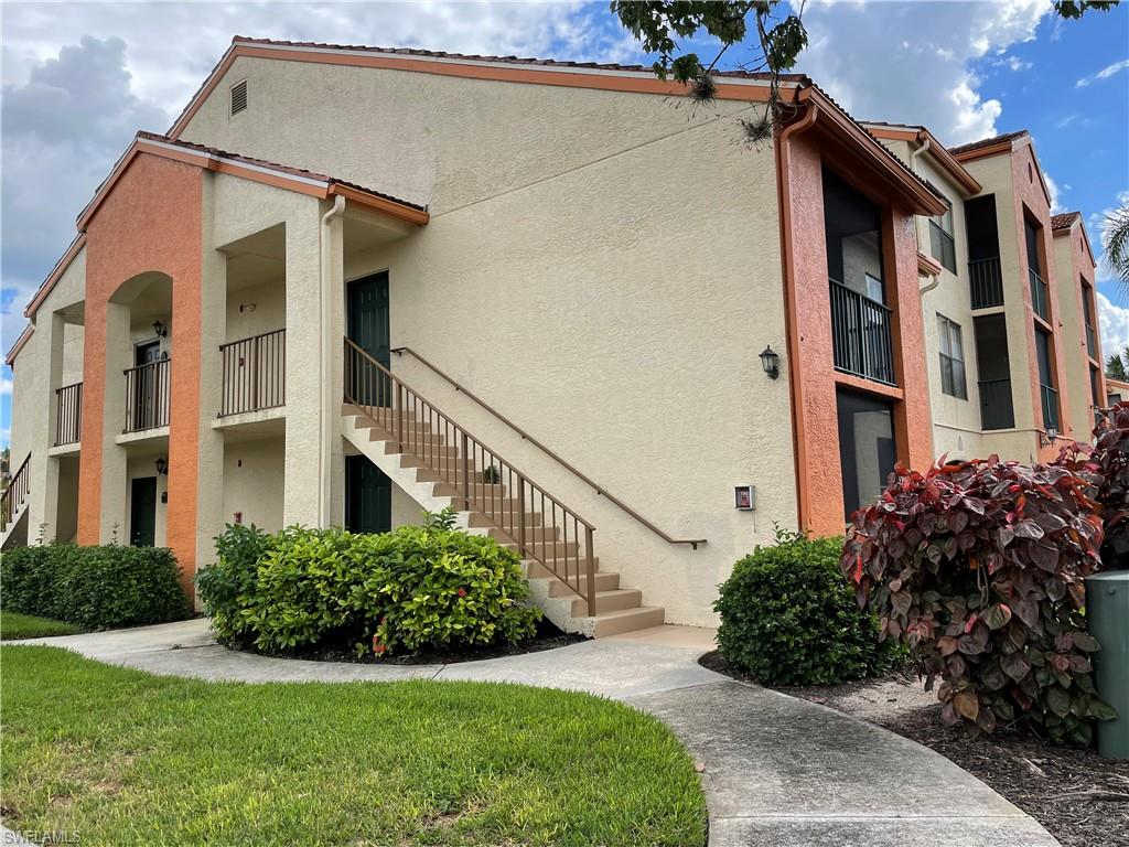 13521 Eagle Ridge Drive, Unit 121 Fort Myers, FL 33912 - Photo 2 of 12 a view of a house with brick walls and a yard with plants