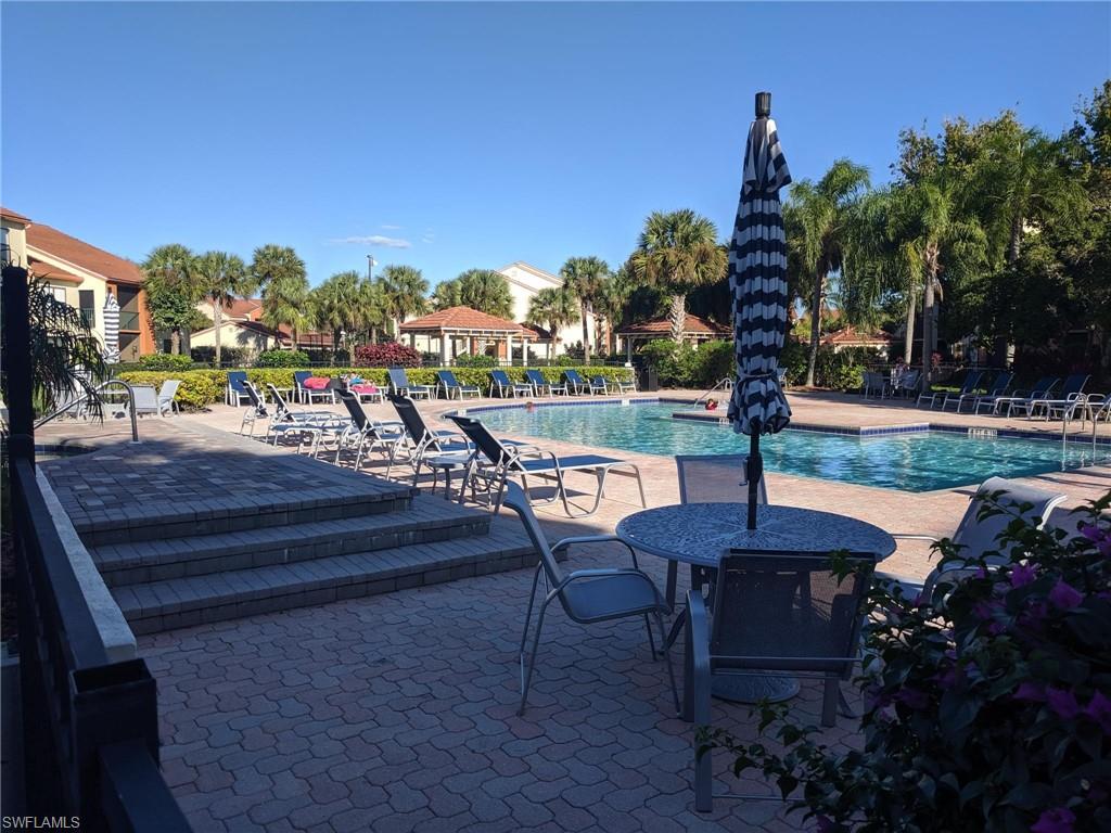 13521 Eagle Ridge Drive, Unit 121 Fort Myers, FL 33912 - Photo 9 of 12 a view of a patio with swimming pool table and chairs
