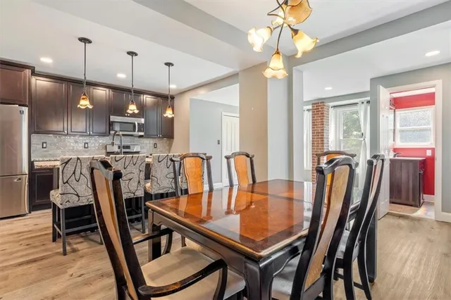 a dining room with furniture a chandelier and window