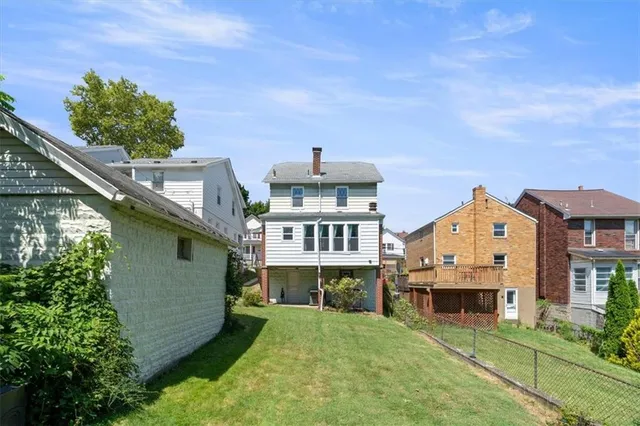 an aerial view of a house with a big yard and large trees