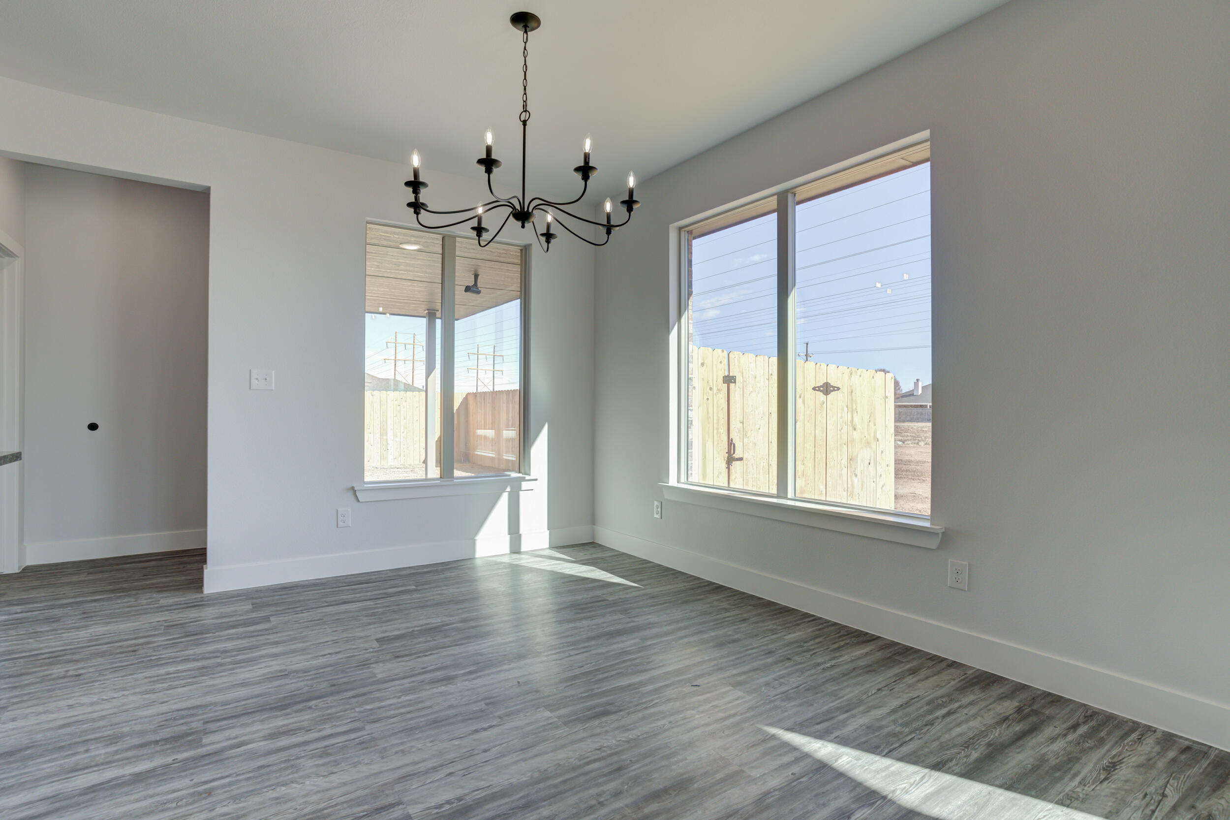 6926 12th Street Lubbock, TX 79416 - Photo 13 of 39 a view of an empty room with a window and wooden floor