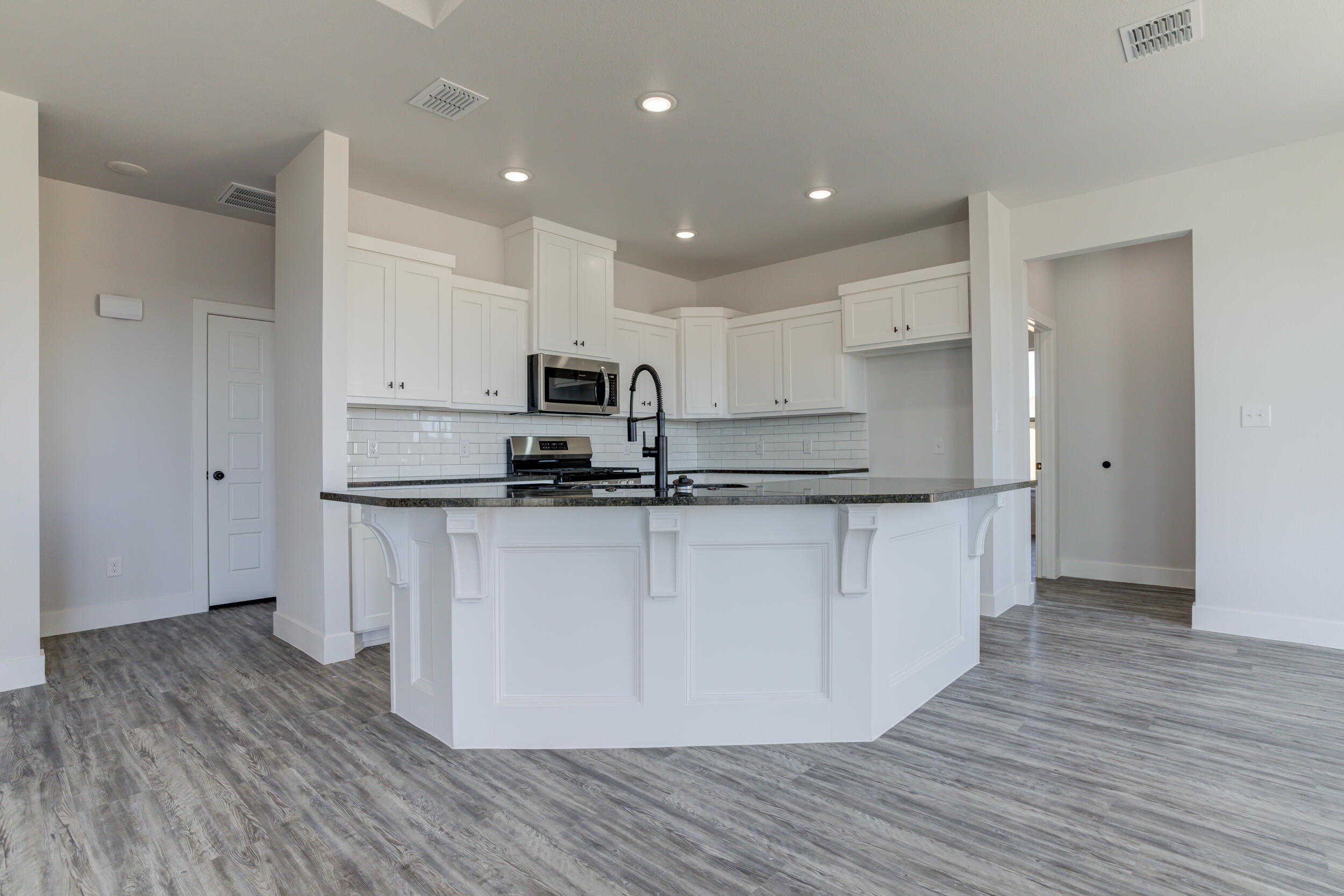 6926 12th Street Lubbock, TX 79416 - Photo 14 of 39 a kitchen with kitchen island white cabinets and stainless steel appliances