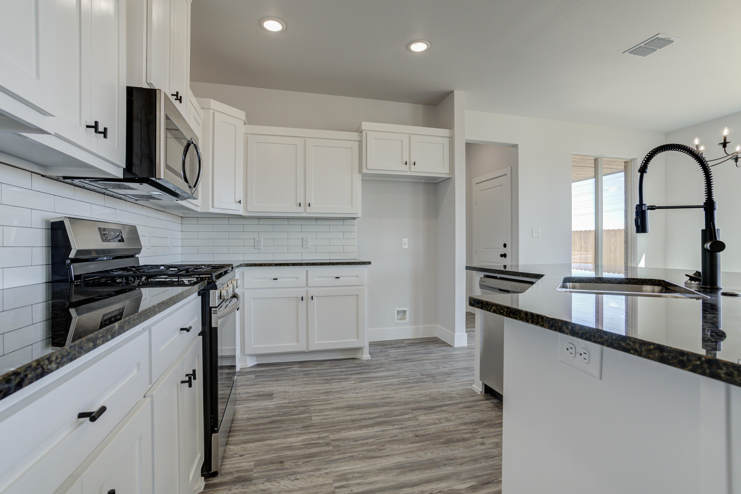 6926 12th Street Lubbock, TX 79416 - Photo 19 of 39 a kitchen with stainless steel appliances granite countertop a stove a sink and a refrigerator