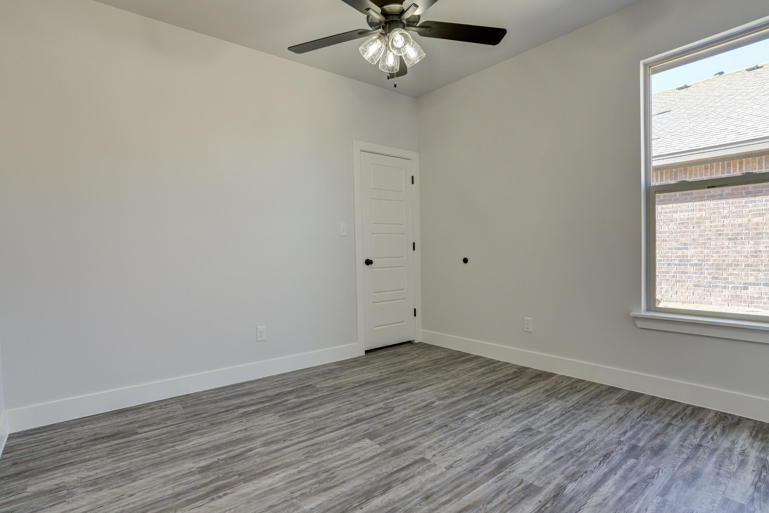 6926 12th Street Lubbock, TX 79416 - Photo 30 of 39 a view of an empty room with wooden floor and a window
