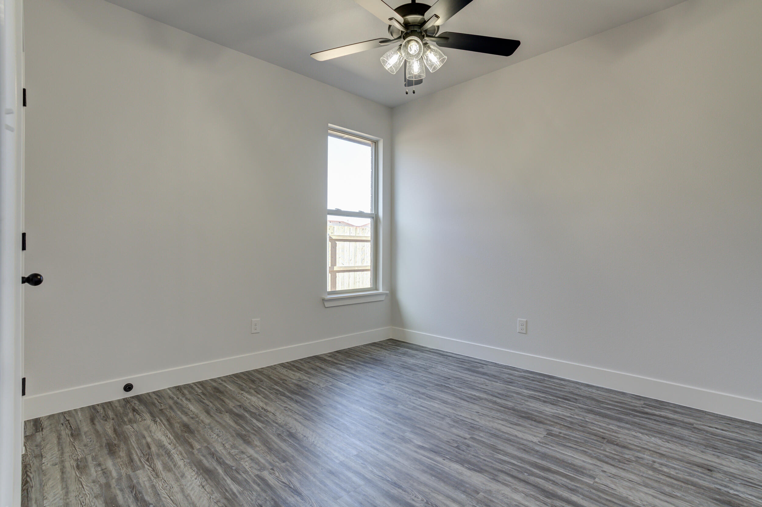 6926 12th Street Lubbock, TX 79416 - Photo 33 of 39 a view of an empty room with wooden floor and a window