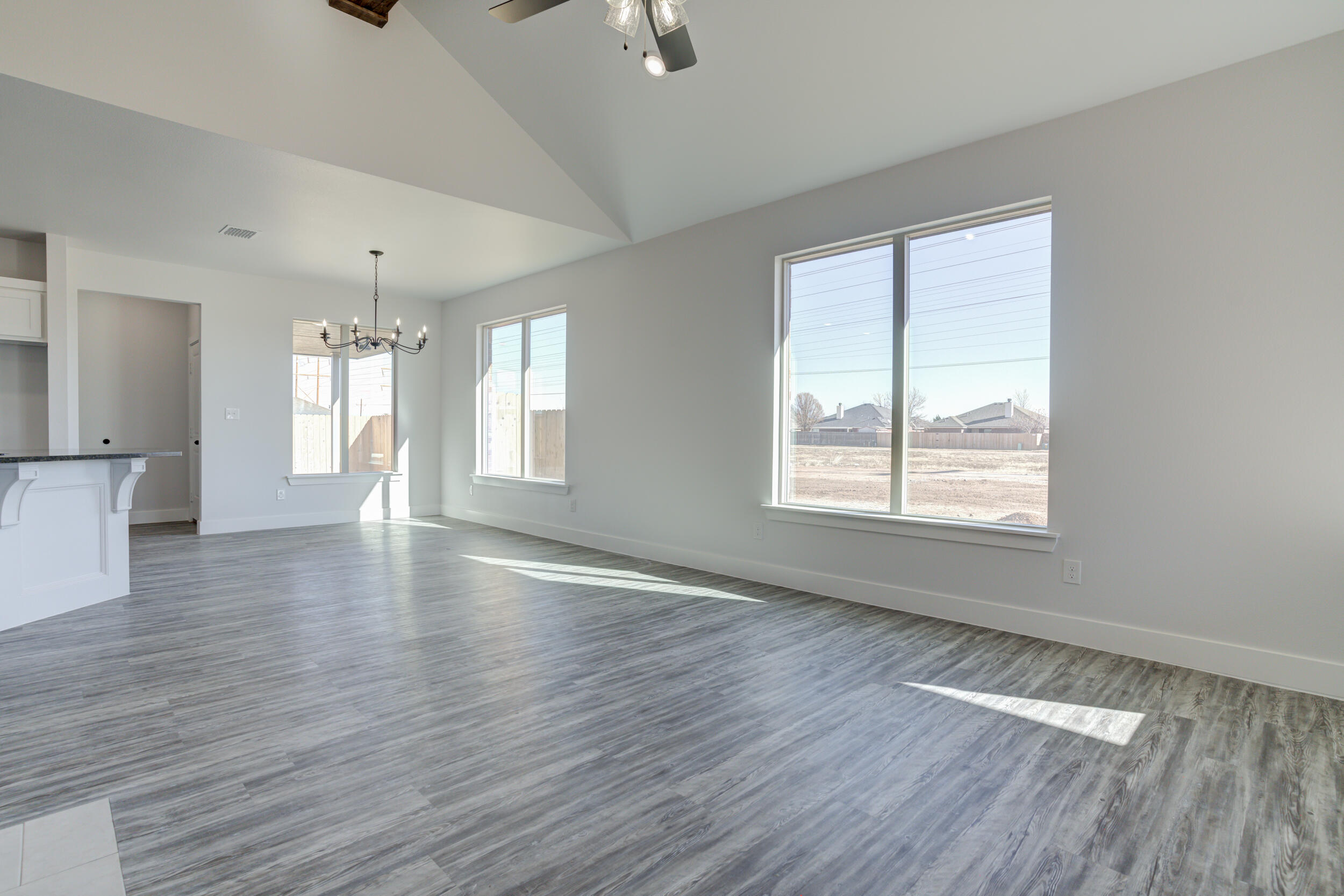 6926 12th Street Lubbock, TX 79416 - Photo 6 of 39 a view of an empty room with wooden floor and a window