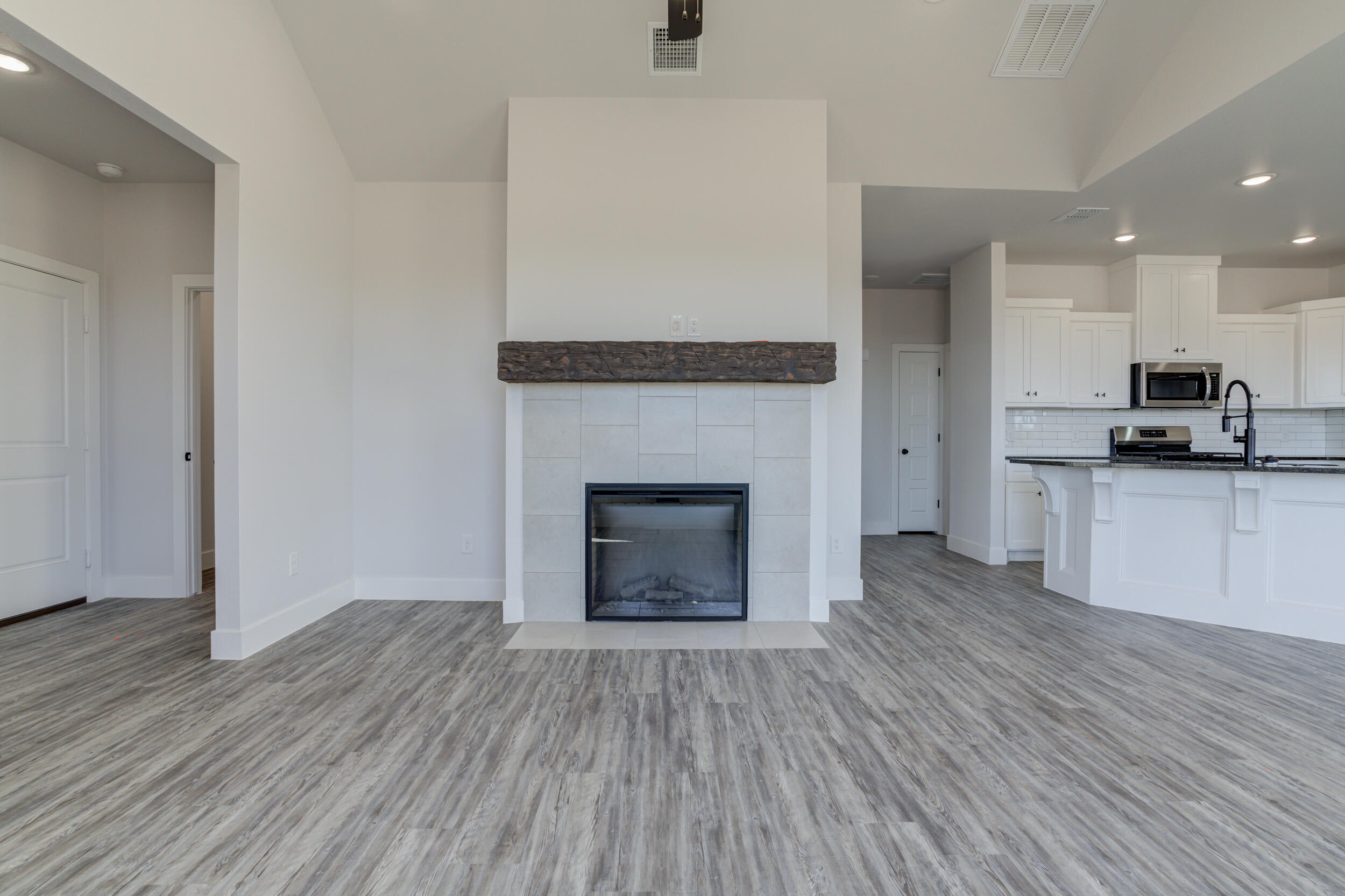 6926 12th Street Lubbock, TX 79416 - Photo 8 of 39 an empty room with wooden floor a fireplace and windows