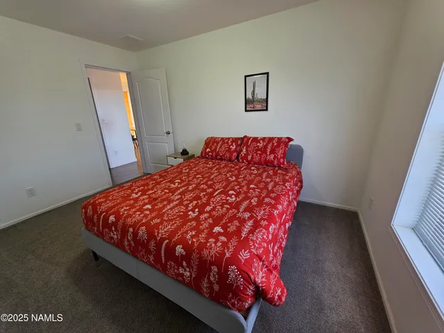 a bed sitting in a bedroom next to a window