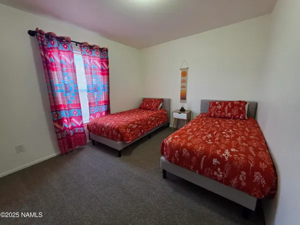 a bedroom with two beds and window