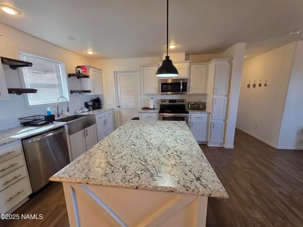 a kitchen with stainless steel appliances granite countertop wooden cabinets a stove top oven a sink and dishwasher