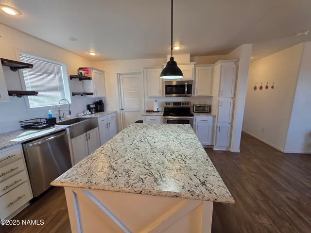 a kitchen with stainless steel appliances granite countertop wooden cabinets a stove top oven a sink and dishwasher