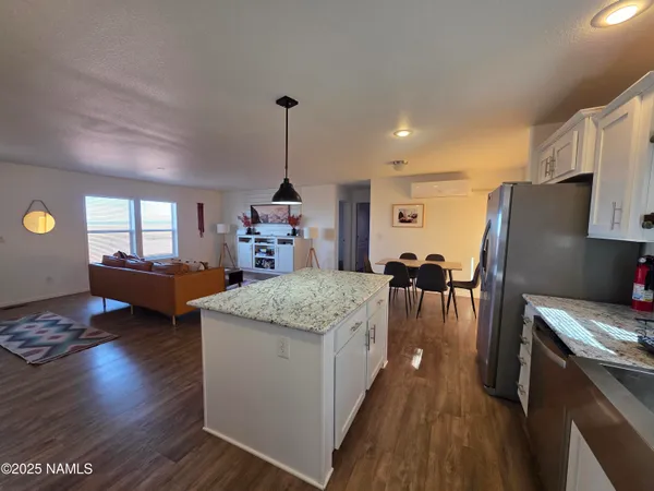 a kitchen with stainless steel appliances granite countertop a refrigerator a stove and a wooden floors