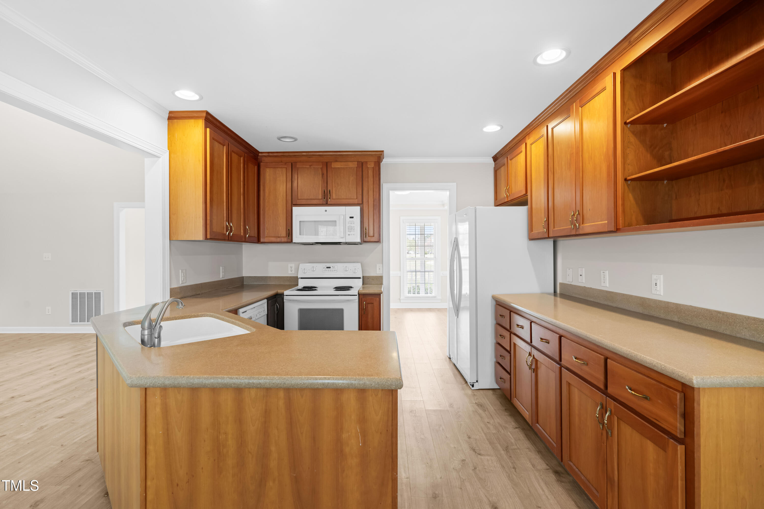 44 Loop Road Archer Lodge, NC 27527 - Photo 11 of 48 a kitchen with stainless steel appliances a stove a sink dishwasher and cabinets with wooden floor