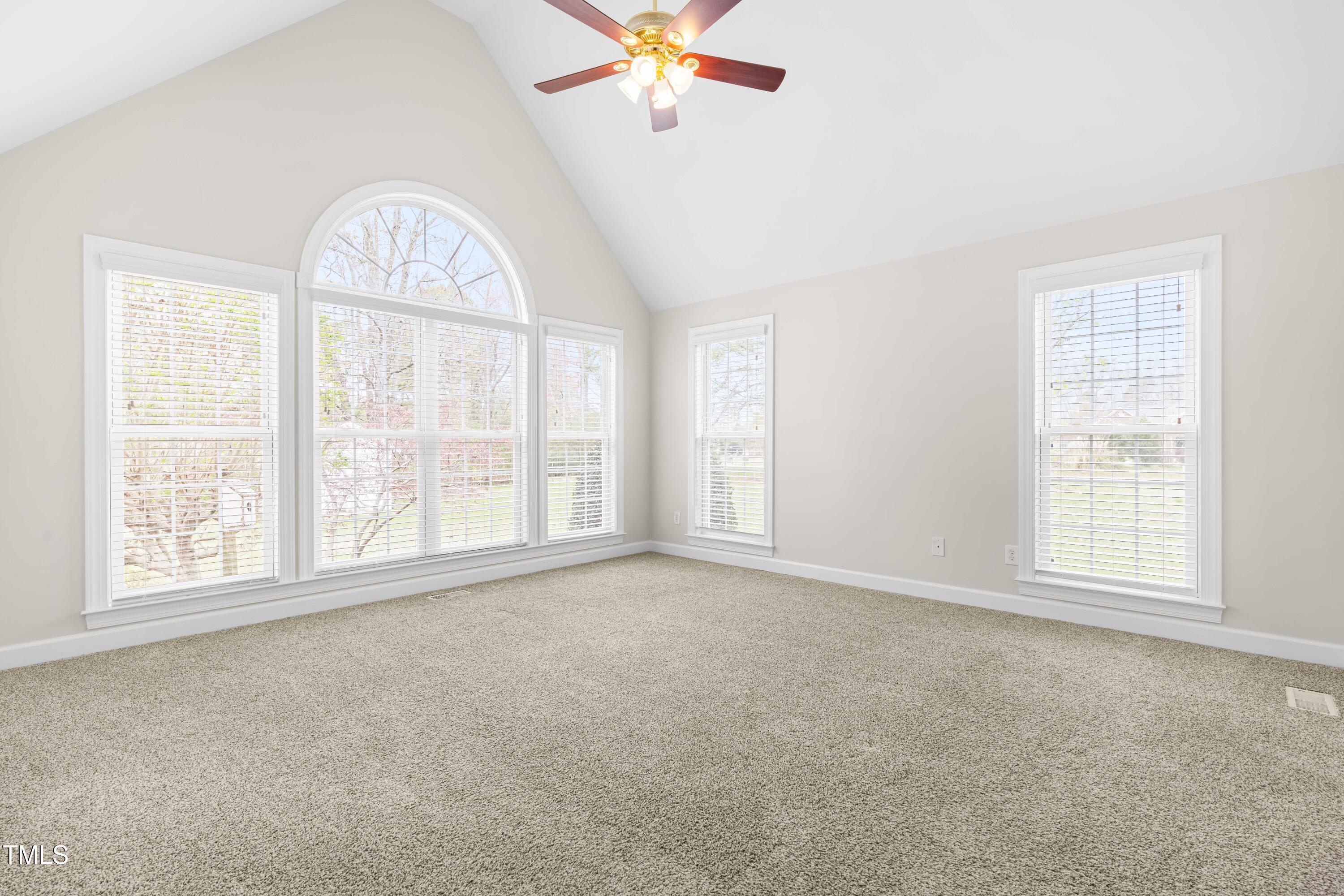44 Loop Road Archer Lodge, NC 27527 - Photo 23 of 48 an empty room with chandelier fan and windows