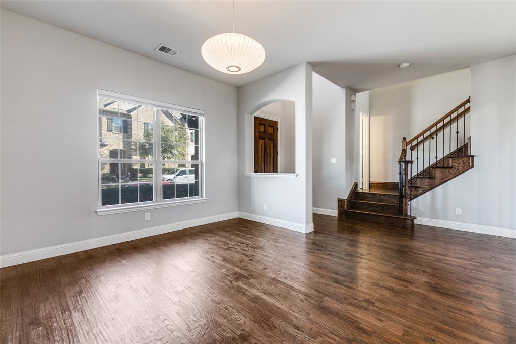 828 Rohan Drive Richardson, TX 75081 - Photo 4 of 25 a view of an empty room with wooden floor and a window