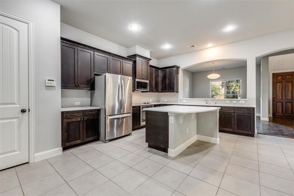 828 Rohan Drive Richardson, TX 75081 - Photo 6 of 25 a kitchen with stainless steel appliances a refrigerator sink and cabinets