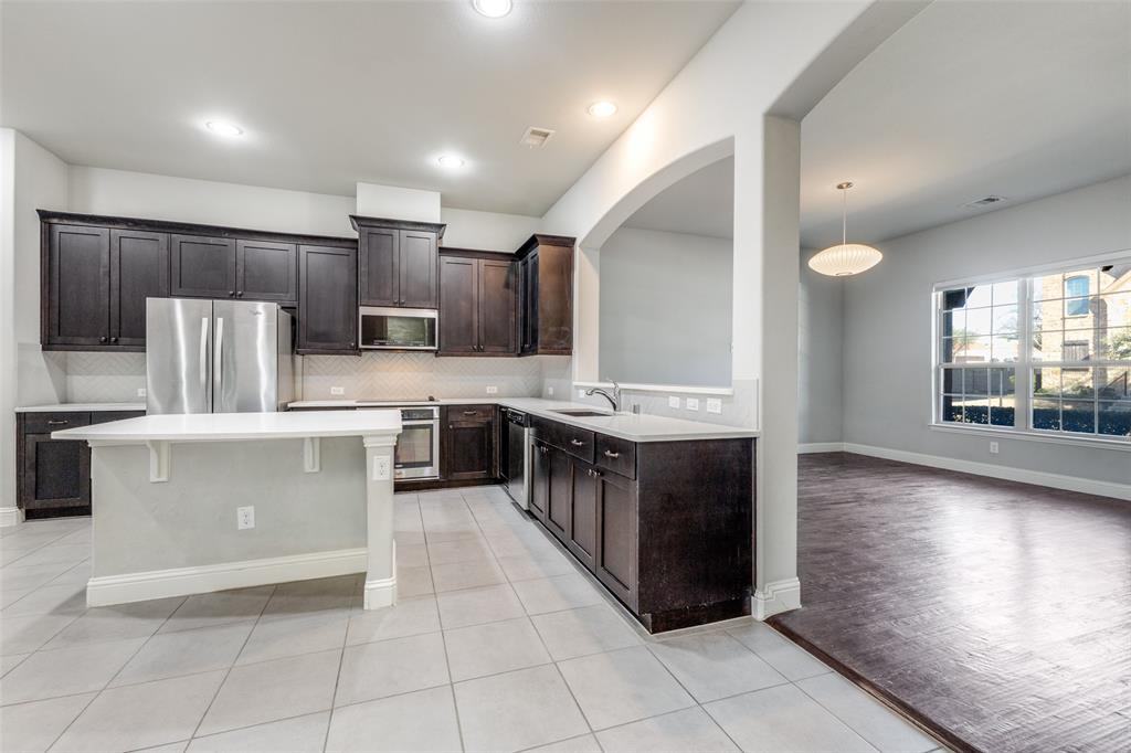 828 Rohan Drive Richardson, TX 75081 - Photo 7 of 25 a kitchen with stainless steel appliances a sink and a stove