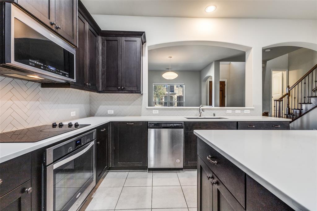 828 Rohan Drive Richardson, TX 75081 - Photo 9 of 25 a kitchen with stainless steel appliances a stove sink microwave and cabinets