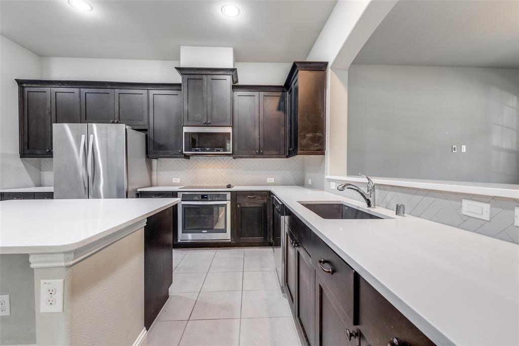 828 Rohan Drive Richardson, TX 75081 - Photo 10 of 25 a kitchen with stainless steel appliances granite countertop a sink stove and refrigerator