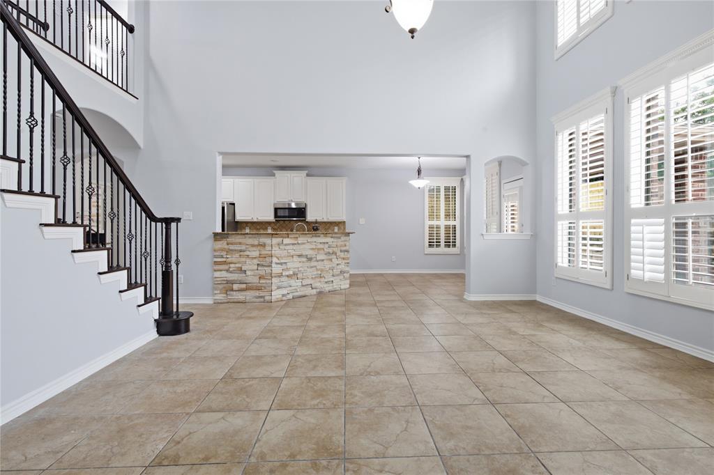 10001 Thurman Road Fort Worth, TX 76244 - Photo 9 of 40 Two-story living area featuring tile flooring, vaulted ceilings, and multiple windows with plantation shutters