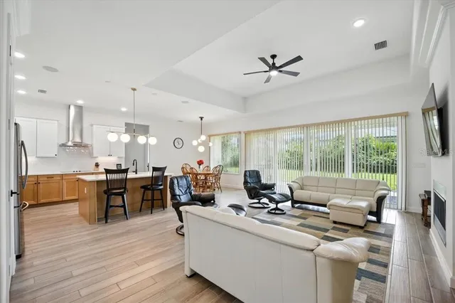 a living room with furniture floor to ceiling window and a flat screen tv