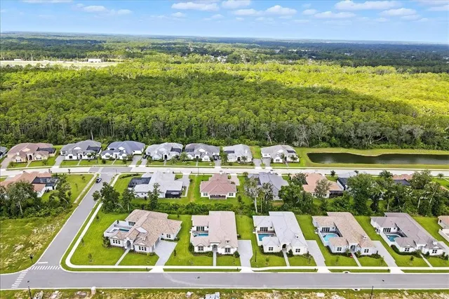 a front view of a house with a yard and a large tree