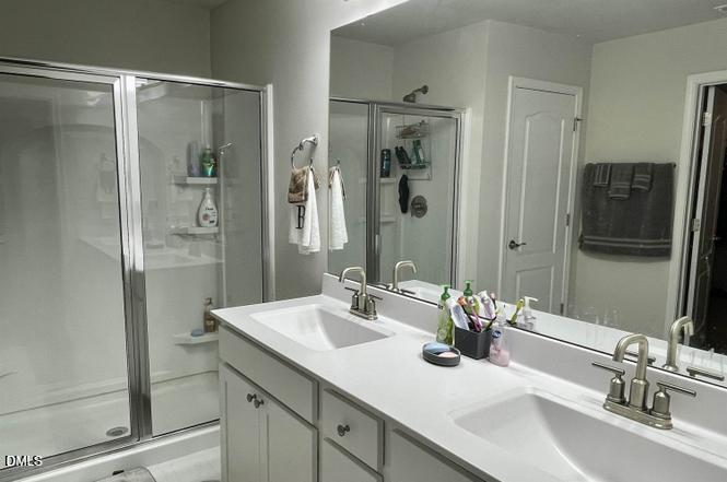 1807 Wrenn Road Durham, NC 27703 - Photo 34 of 43 a bathroom with a shower sink and mirror
