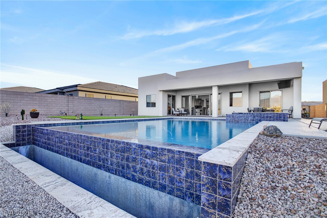 1460 Blue Ridge Trail Mesquite, NV 89027 - Photo 27 of 39 An inviting backyard oasis offers a pristine pool with a striking tiled edge, ready for warm days.