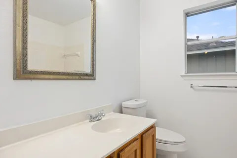 a bathroom with a sink a toilet and a mirror