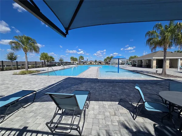 a swimming pool with outdoor seating and yard
