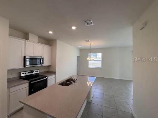 a kitchen with kitchen island and stainless steel appliances