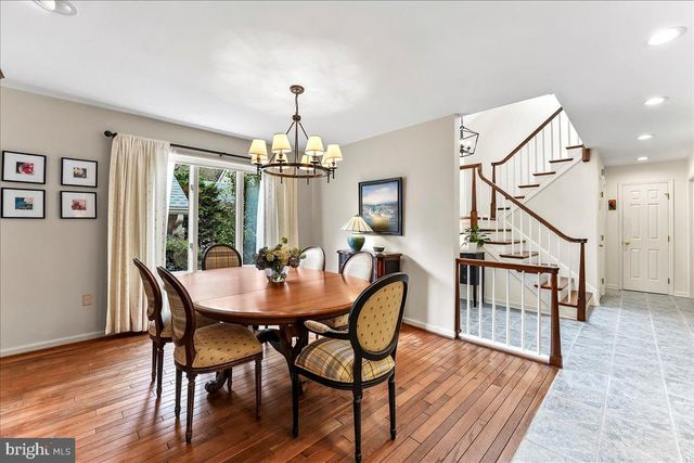 a living room with furniture large window and wooden floor