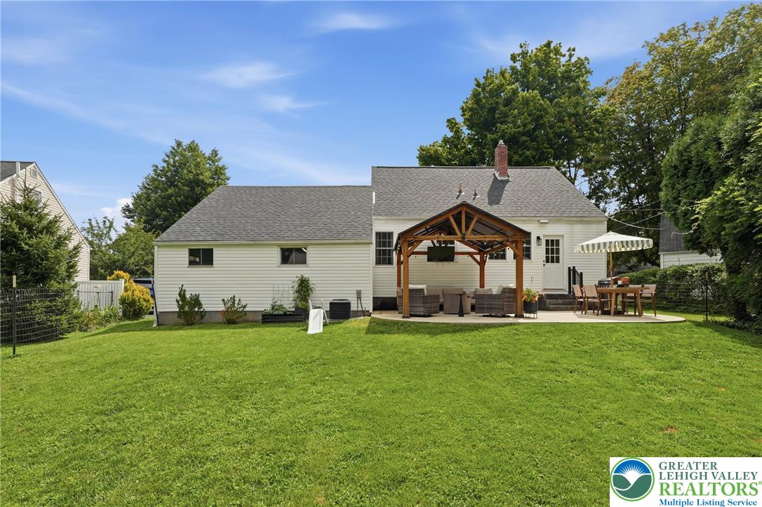 408 Maple Road Hellertown, PA 18055 - Photo 53 of 66 An expansive green lawn stretches toward a rear patio complete with a wooden pavilion structure.