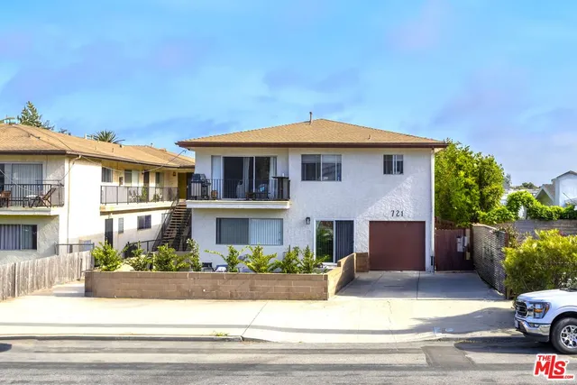 a front view of a house with garage and plants