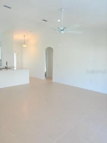 an empty room with kitchen view and kitchen view