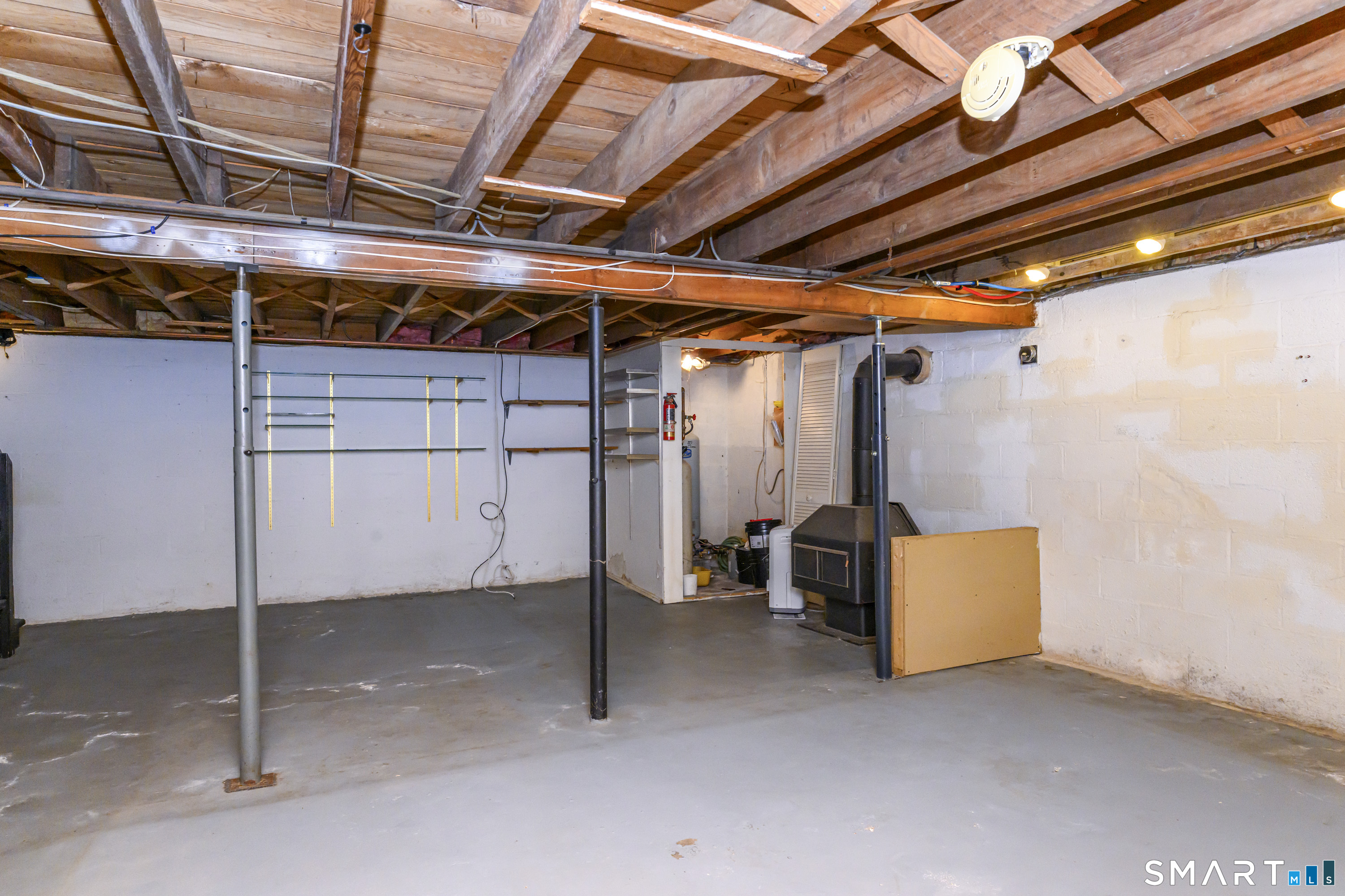 39 Rocky Ledge Drive Clinton, CT 06413 - Photo 28 of 40 Use your imagination to finish the basement and enjoy the wood-burning stove!